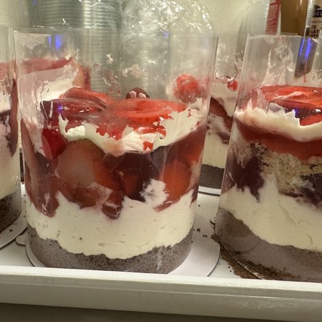 Layered strawberry shortcake dessert cups with cream, cake and fresh strawberries