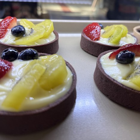 Chocolate crust tarts topped with custard, strawberry, kiwi and blueberries