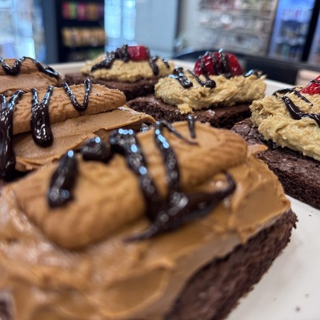 Brownie bars topped with peanut butter frosting, chocolate drizzle and strawberries