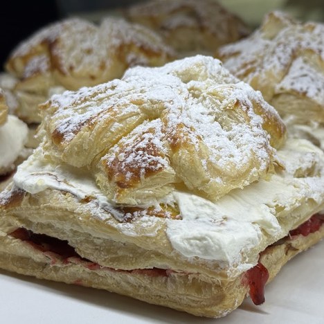 Flaky puff pastry squares filled with cream and strawberry, dusted with powdered sugar